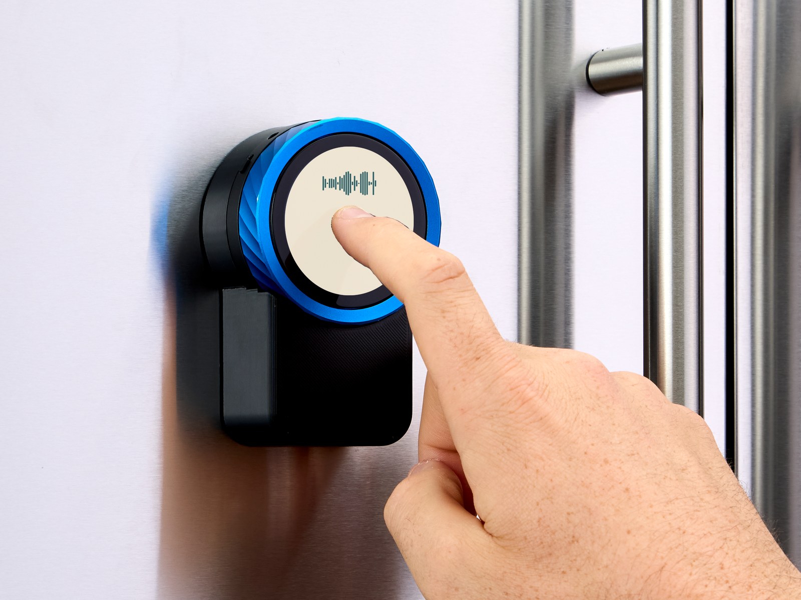 A finger pressing the button on the Trepo device to speak to it